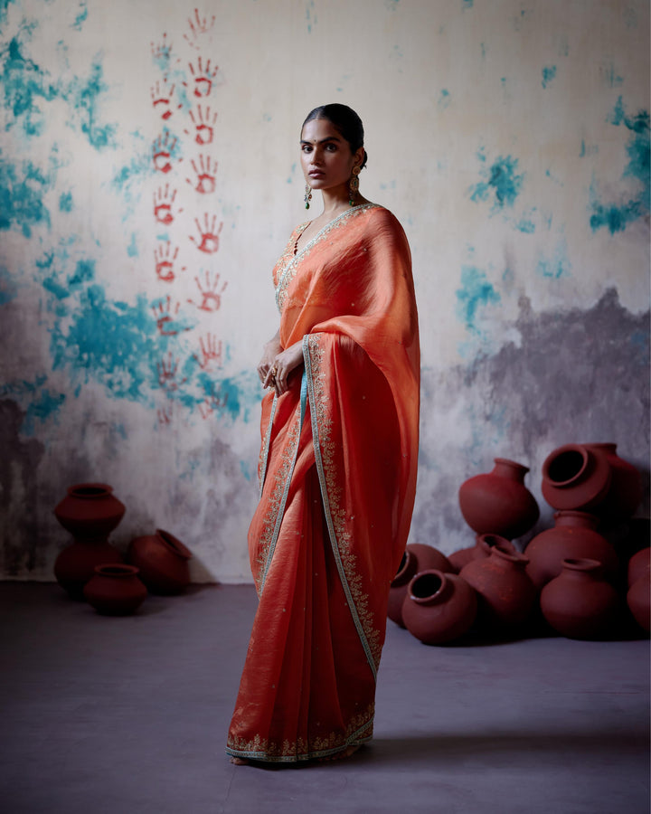 rust orange half and half saree with sleeveless blouse