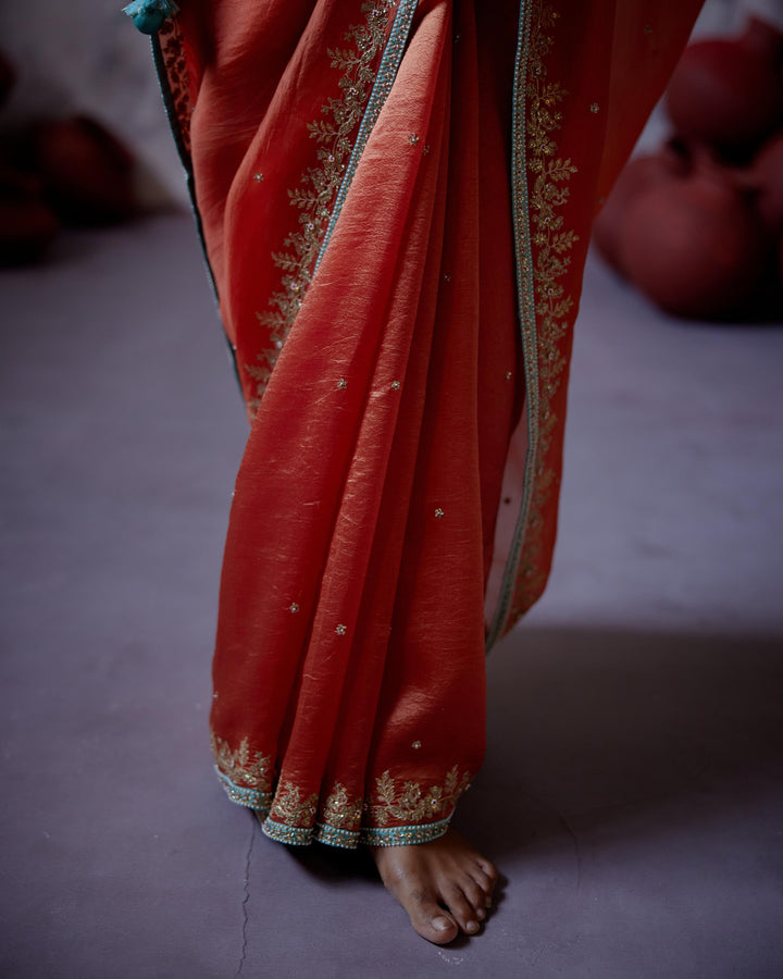 rust orange half and half saree with sleeveless blouse