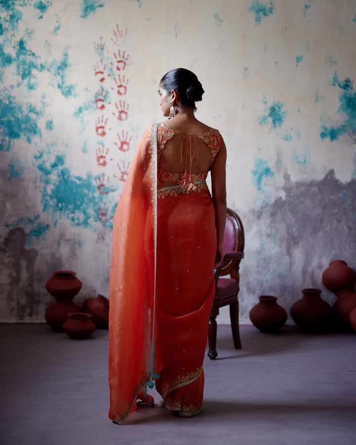 rust orange half and half saree with sleeveless blouse