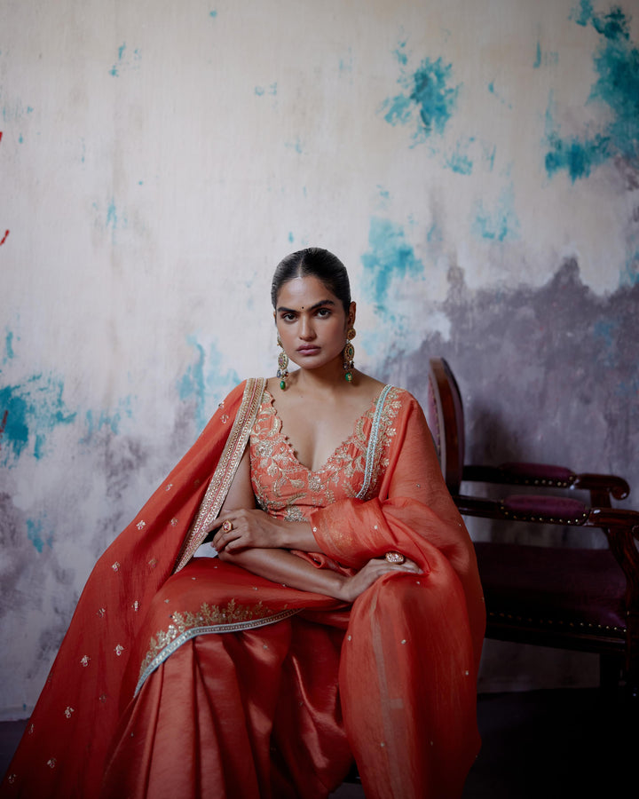 rust orange half and half saree with sleeveless blouse