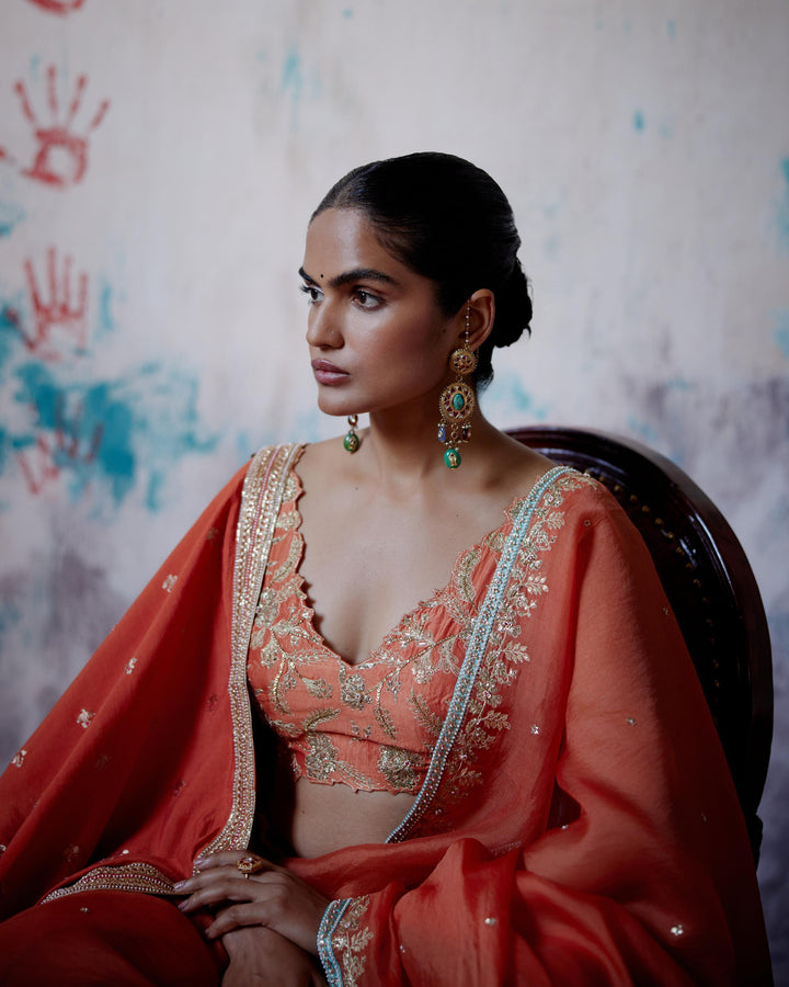 rust orange half and half saree with sleeveless blouse