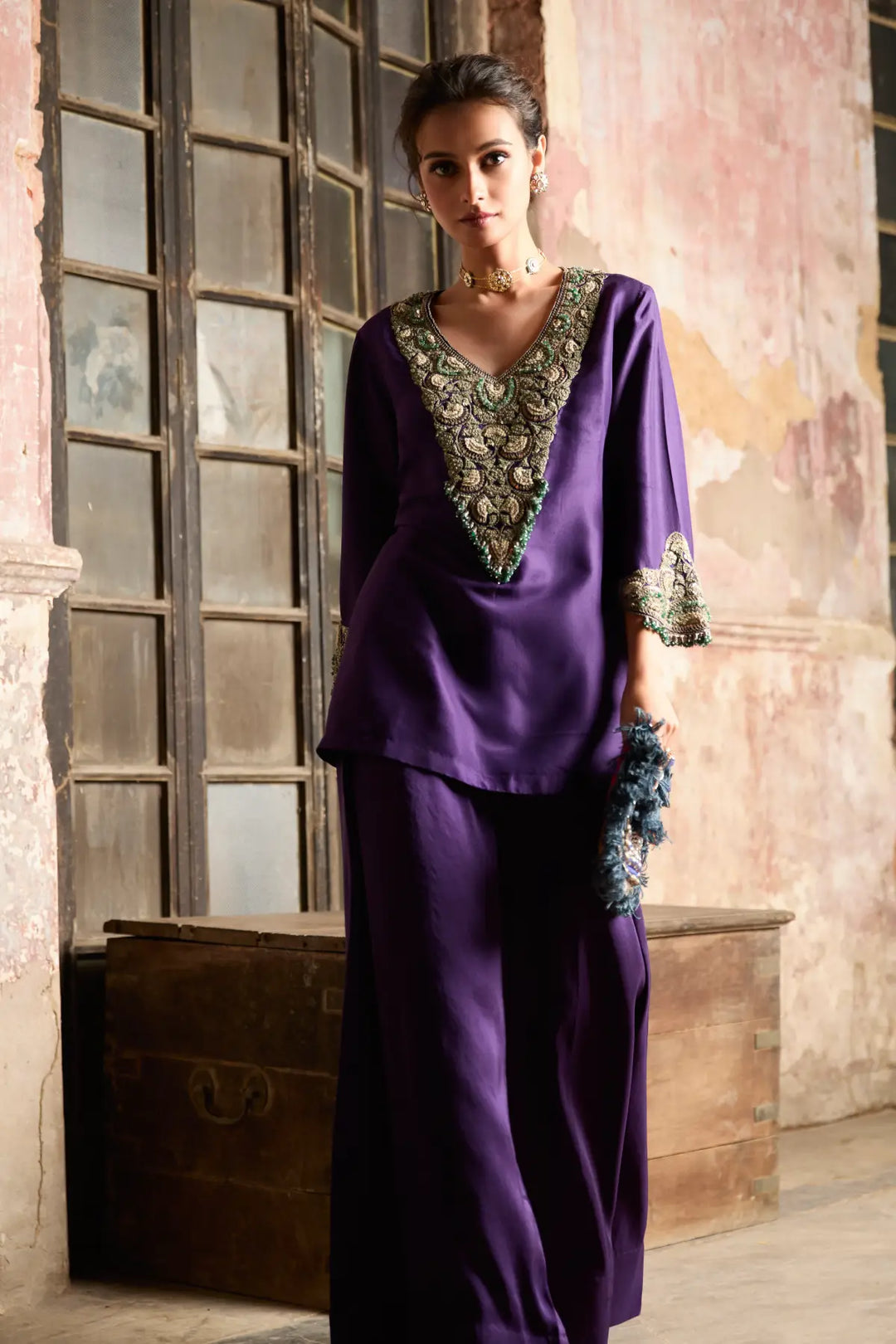 Woman wearing a purple co-ord set with intricate detailing in a rustic setting