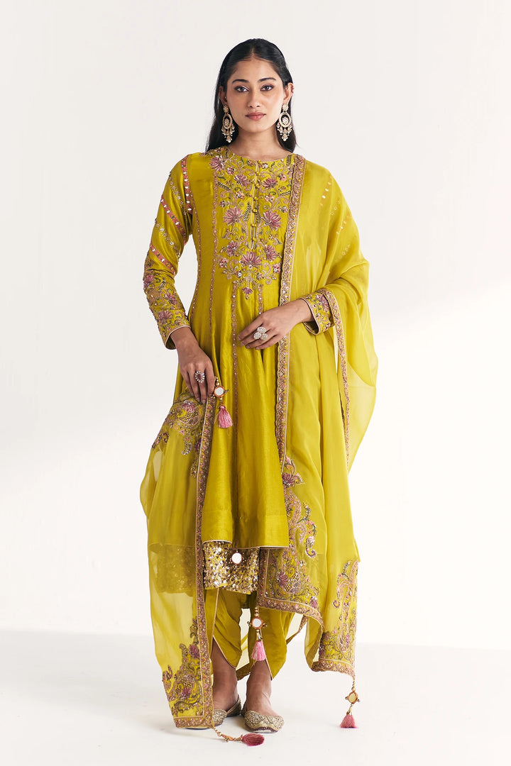Woman wearing a yellow embroidered traditional Anarkali on a white background