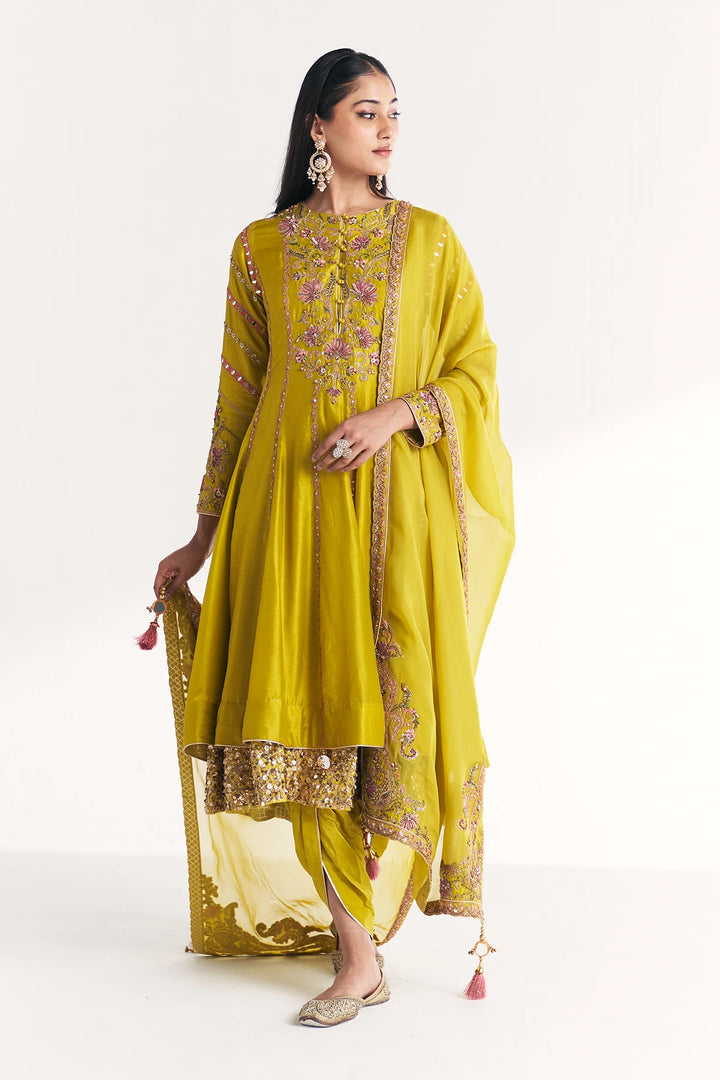 Woman wearing a yellow traditional Anarkali with embroidery on a white background