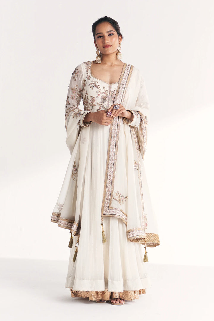 Woman wearing a traditional Anarkali with floral patterns on a white background