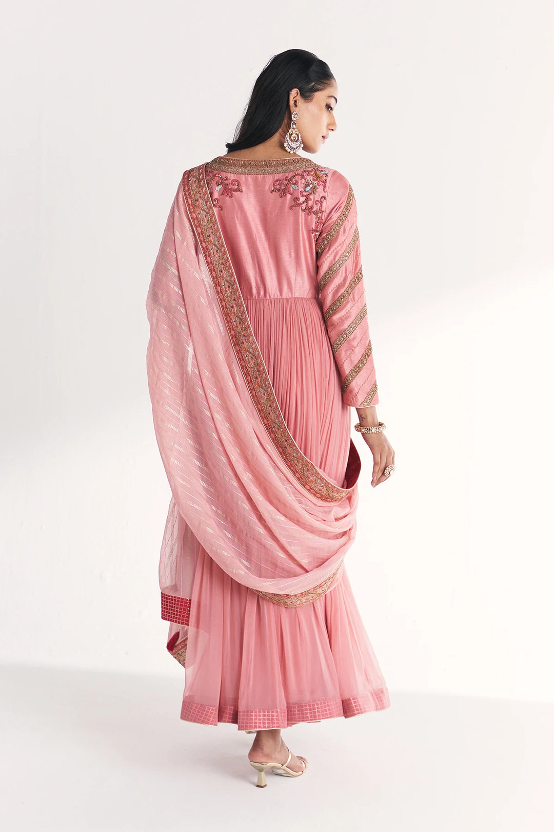 Woman wearing a pink traditional Anarkali with a white background