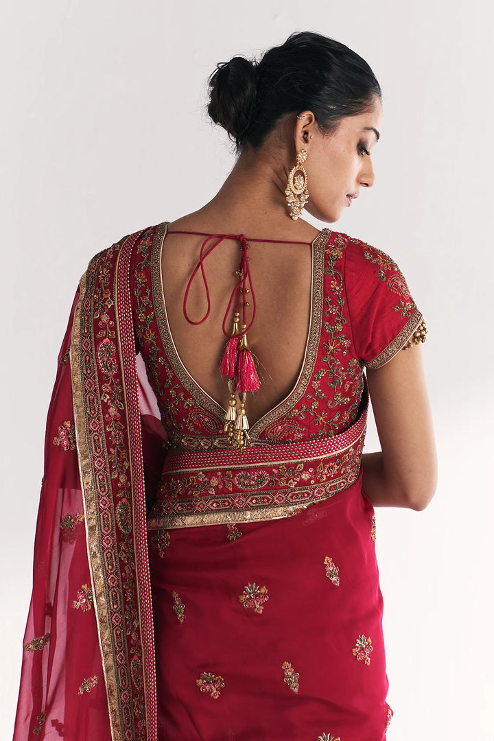 Red embroidered saree with gold details on a white background