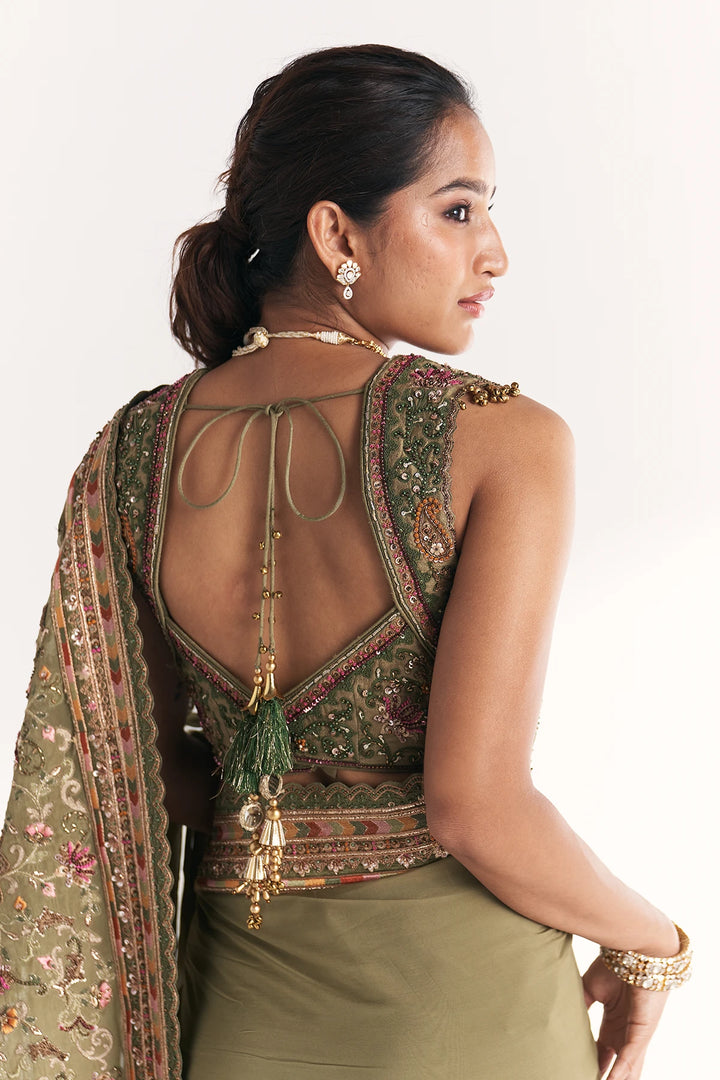 Woman wearing an ornate traditional outfit with a backless design on a white background