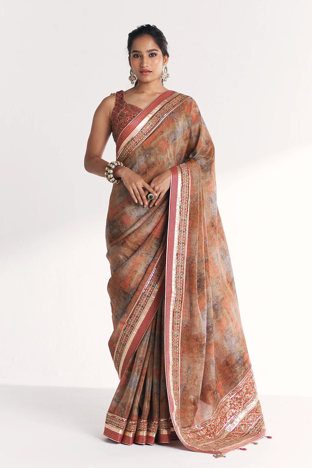 Woman wearing a patterned saree on a white background