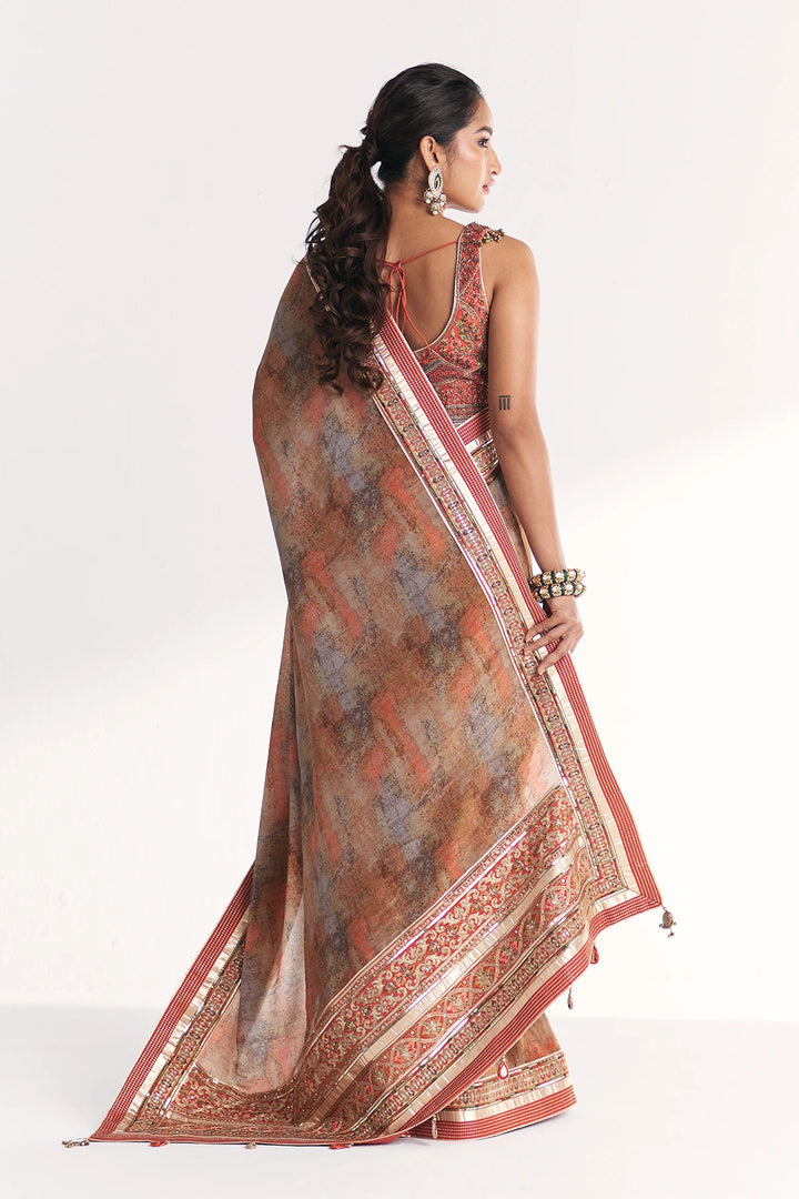 Woman wearing a patterned saree on a white background