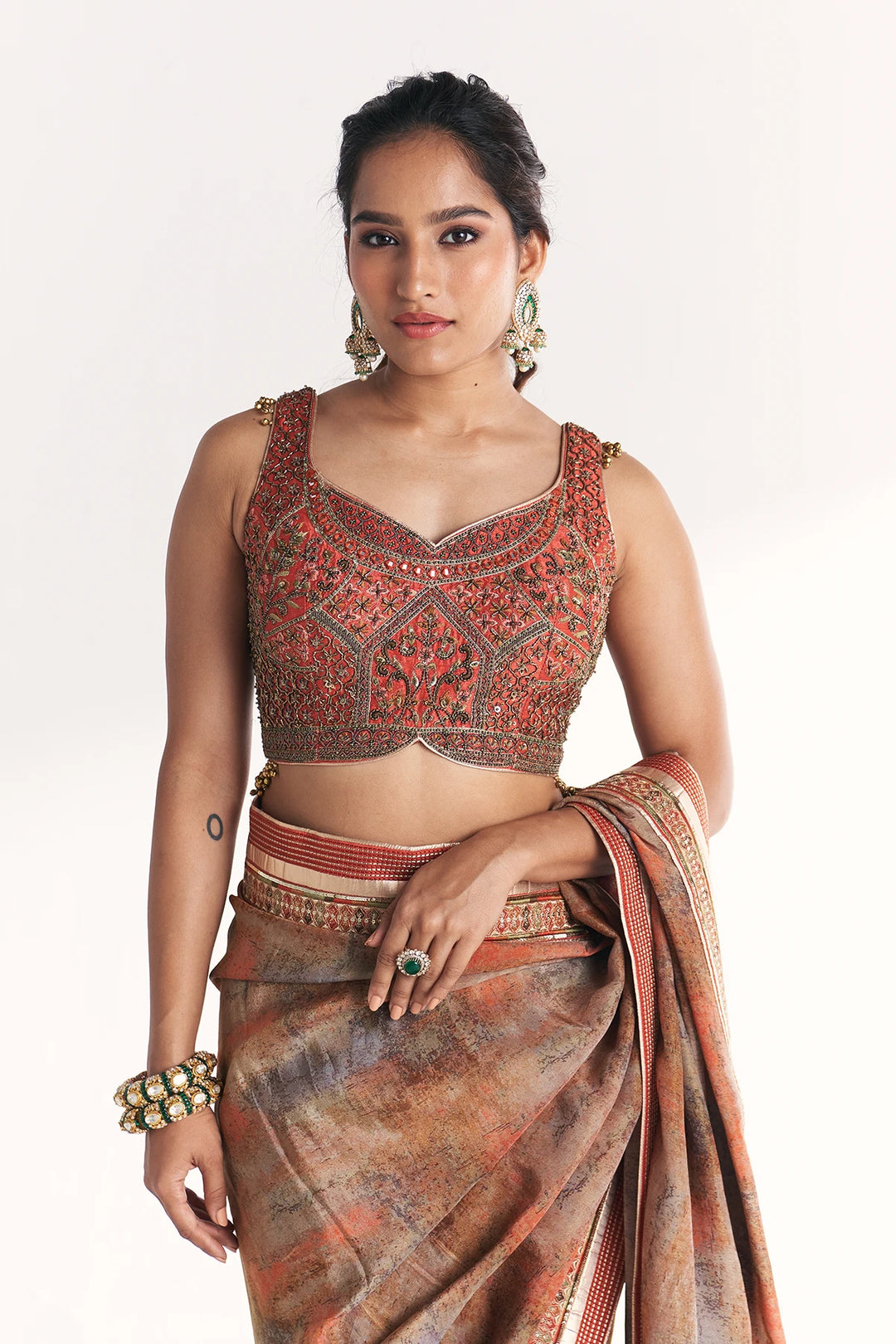 Woman wearing a traditional outfit with a blouse and saree on a white background