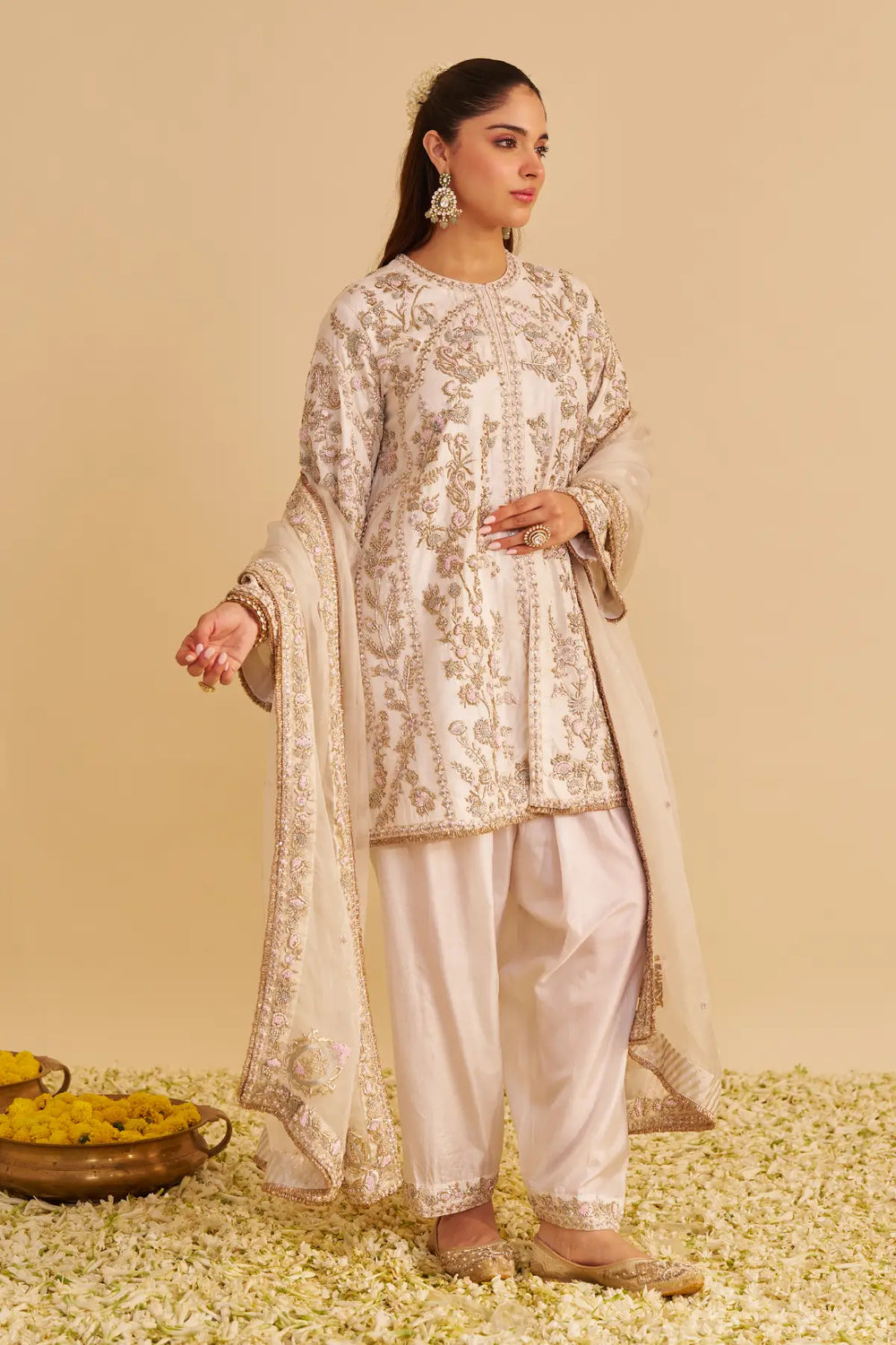 Woman in traditional embroidered outfit with a beige background