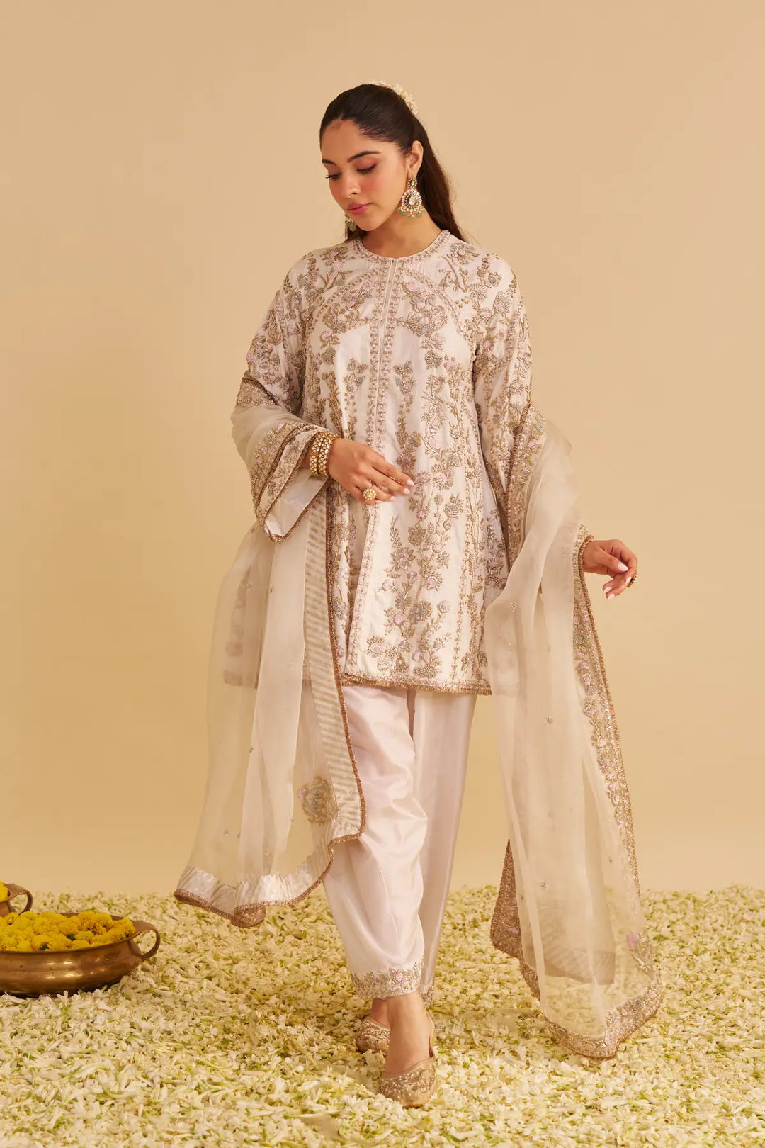 Woman in traditional outfit with floral patterns on a beige background