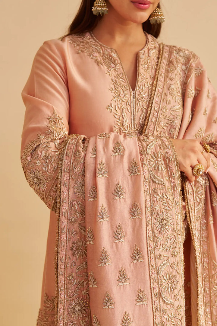 Pink embroidered traditional kurta with gold details on a beige background