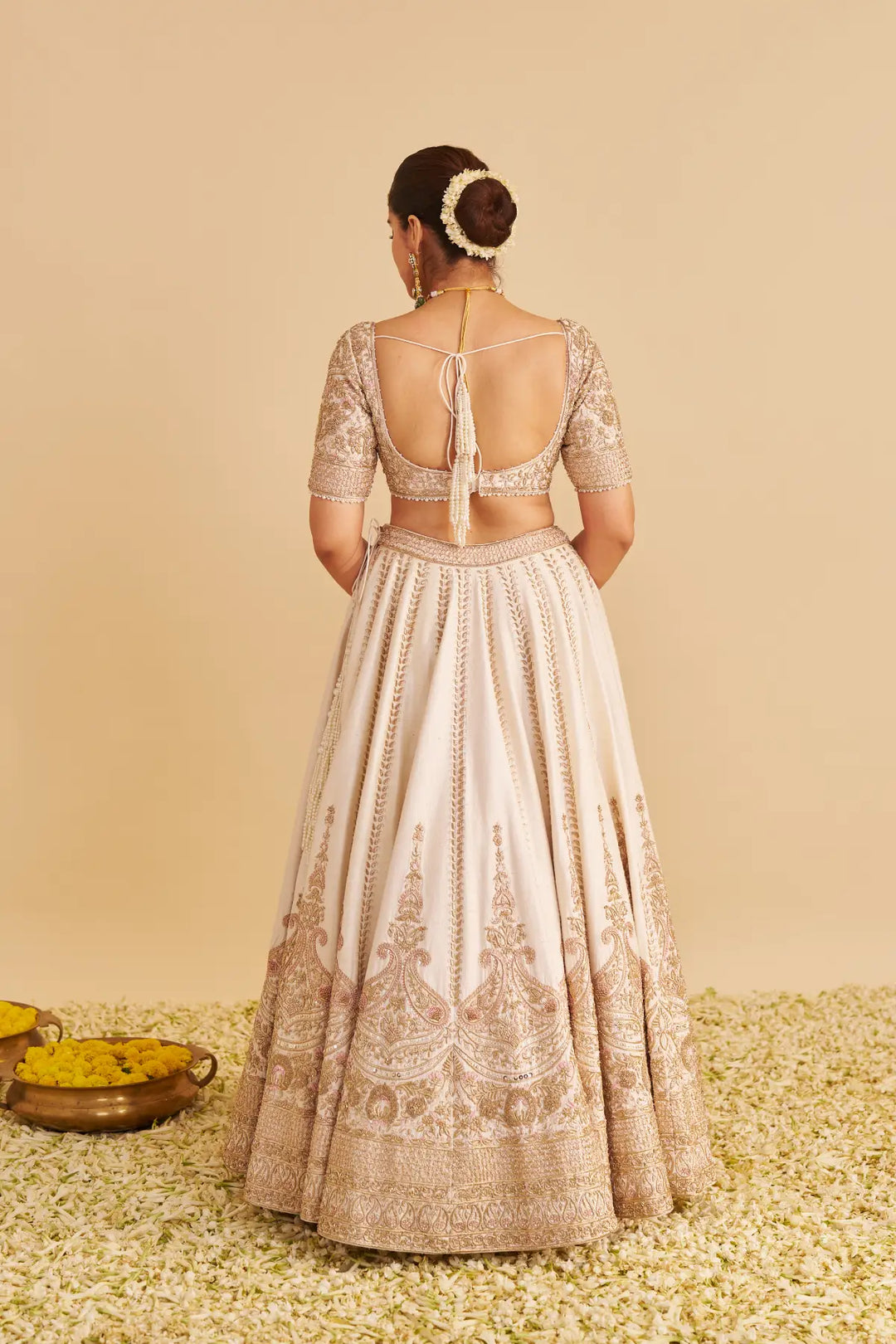 Woman wearing a traditional outfit with intricate patterns on a beige background