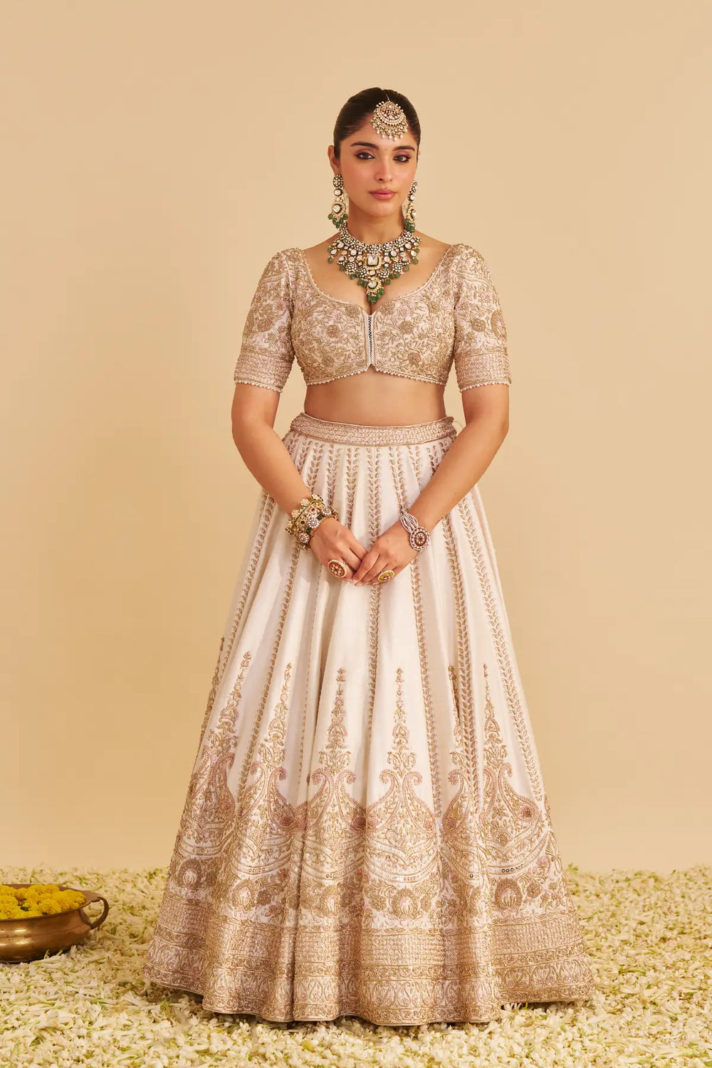 Woman wearing a traditional embroidered outfit on a beige background