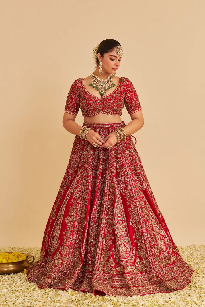 Red traditional outfit with intricate patterns on a beige background