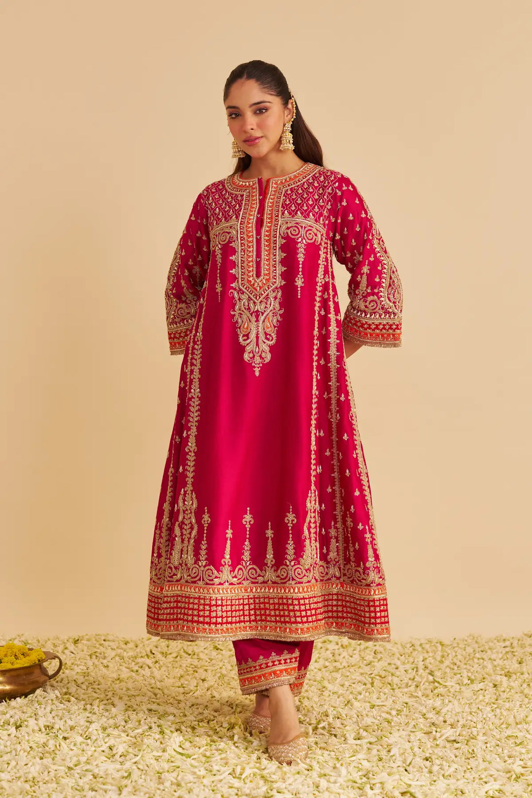 Woman wearing a red embroidered traditional Chauga on a beige background